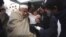 An injured driver (in white) who survived a shooting by unidentified gunmen in Swabi, arrives at the Lady Reading Hospital in Peshawar, January 1, 2013.