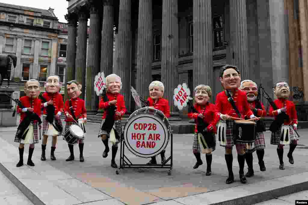 Oxfam activists with 'Big Heads' of Russia's President Vladimir Putin, Italy's Prime Minister Mario Draghi, France's President Emmanuel Macron, U.S. President Joe Biden, Britain's Prime Minister Boris Johnson, Germany's Chancellor Angela Merkel, Canada's Prime Minister Justin Trudeau, India's Prime Minister Narendra Modi and China's President Xi Jinping perform in a Scottish pipe band, as the U.N. Climate Change Conference (COP26) takes place in Glasgow.