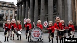 Oxfam activists with 'Big Heads' of Russia's President Vladimir Putin, Italy's Prime Minister Mario Draghi, France's President Emmanuel Macron, U.S. President Joe Biden, Britain's Prime Minister Boris Johnson, Germany's Chancellor Angela Merkel, Canada's Prime Minister Justin Trudeau, India's Prime Minister Narendra Modi and China's President Xi Jinping perform in a Scottish pipe band, as the U.N. Climate Change Conference (COP26) takes place in Glasgow.
