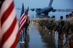 Paratroopers assigned to 1st Brigade Combat Team, 82nd Airborne Division walk as they prepare equipment and load aircraft bound for the US Central Command area of operations from Fort Bragg, Jan. 4, 2020. (US Army photo)