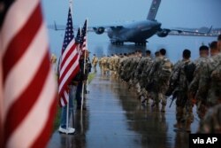 Paratroopers assigned to 1st Brigade Combat Team, 82nd Airborne Division walk as they prepare equipment and load aircraft bound for the US Central Command area of operations from Fort Bragg, Jan. 4, 2020. (US Army photo)