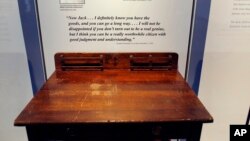 FILE - A desk is displayed in the exhibit titled "Young Jack" at the John F. Kennedy Presidential Library and Museum in Boston. An archivist at Choate, the private school in Connecticut where the president studied as a boy, insists the desk didn't belong to him.