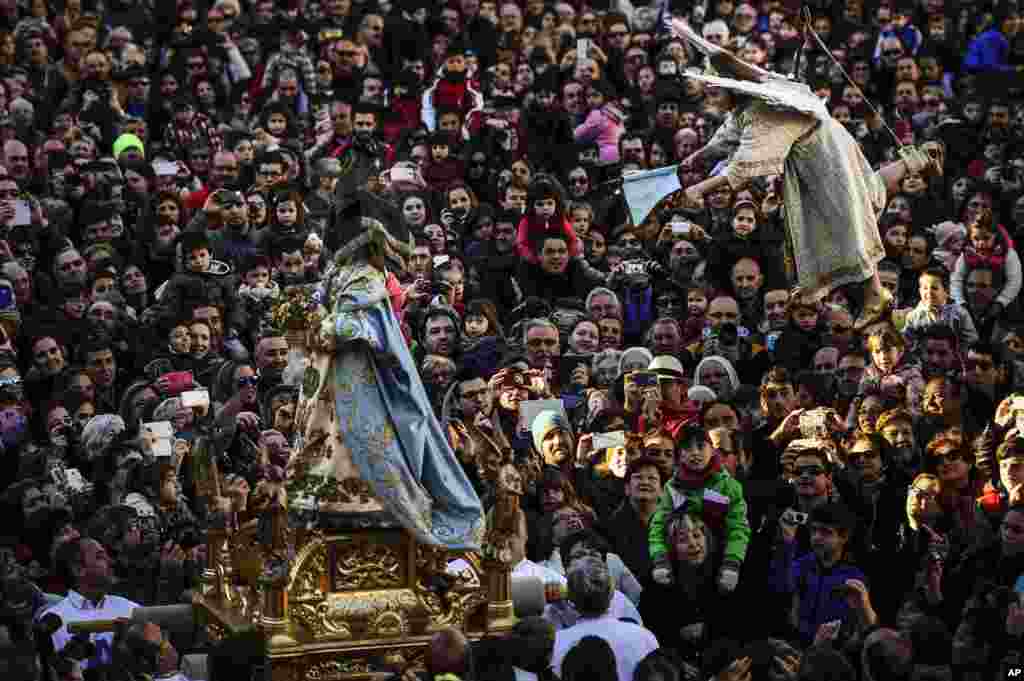 Alba Oroz, 8, secured by a harness, is transported in the air, above the crowd as she unveils the face of a statue of the Virgin Mary, during the Easter Sunday ceremony &#39;&#39;Descent of the Angel&#39;&#39;, during Holy Week in the small town of Tudela, northern Spain, April 5, 2015.