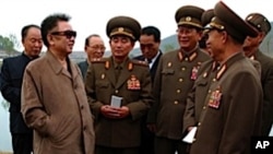 ທ່ານ Kim Jong Il ຜູ້ນໍາເກົາຫຼີເໜືອ ທີ 2 ຈາກຊ້າຍໃສ່ແວ່ນຕາ
ເວົ້າກັບພວກນາຍພົນທະຫານຈຸນຶ່ງ ເວລາໄປຢ້ຽມຢາມຟາມຂອງກອງ ທັບແຫ່ງນຶ່ງ ໃນເກົາຫລີເໜືອ