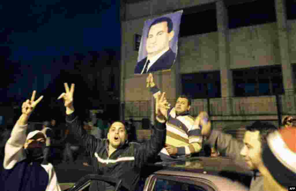 A group of pro-government supporters take to the streets holding a poster of Egyptian President Hosni Mubarak after his speech, in the Imbaba neighborhood of Cairo, Egypt, Wednesday, Feb. 2, 2011. After Mubarak announced Tuesday he would not run for a new