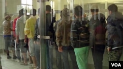 Residents of the reception center for migrants and asylum-seekers in Traiskirchen, Austria, are seen lining up for food at the camp's kitchen. (Photo - VOA video grab)