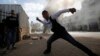 A young Palestinian protester throws stones at Israeli troops during clashes following an anti-Israel demonstration in solidarity with al-Aqsa mosque, in the West Bank city of Hebron, Nov. 14, 2014.