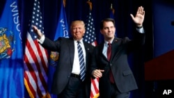 FILE - Governor Scott Walker winks as he walks offstage after introducing then-Republican presidential candidate Donald Trump at a campaign rally at the University of Wisconsin campus in Eau Claire, Nov. 1, 2016.