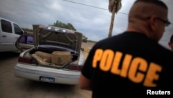 A car filled with bales of marijuana is seen at a police station in La Grulla, Texas March 28, 2013. When police tried to pull the car over, the driver led officers on a high speed pursuit, driving the car into the Rio Grande river. The driver abandoned t