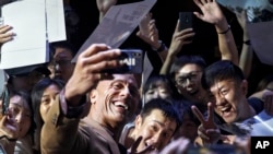 Aktor laga Dwayne Johnson berswafoto dengan para penggemarnya sebelum penayangan perdana film "Fast & Furios: Hobbs & Shaw" di Beijing, 5 Agustus 2019. (Foto: AP)