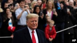 President Donald Trump pauses in front of the press as he and first lady Melania Trump prepare to board Marine One on the South Lawn of the White House in Washington, Jan. 13, 2020.