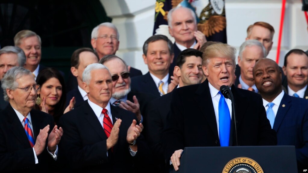 El presidente de EE.UU., Donald Trump, acompañado del vicepresidente Mike Pence (segundo desde la derecha) y los legisladores de la mayoría republicana en el Congreso, celebran la aprobación de la reforma a la ley de impuestos, la mayor victoria del gobierno de Trump.