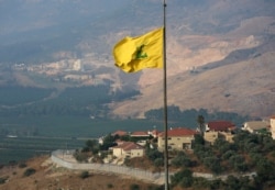 FILE - A Hezbollah flag flutters in the southern Lebanese village of Khiam, near the border with Israel, Lebanon, July 28, 2020.