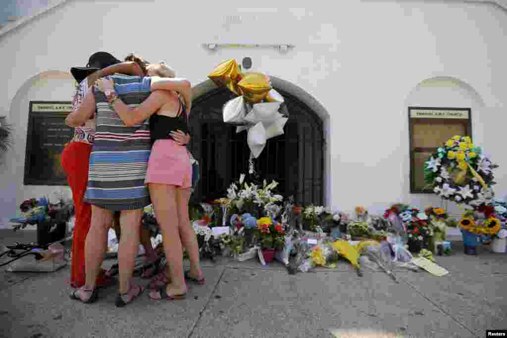 Mourners hug after praying outside the Emanuel African Methodist Episcopal Church in Charleston, South Carolina, June 18, 2015.