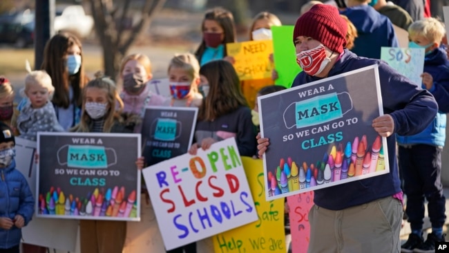 FILE - Students who attend Salt Lake City School District schools rally at East High School Monday, Dec. 7, 2020, in Salt Lake City, urging the school board and administrators to restart in-person learning. (AP Photo/Rick Bowmer)