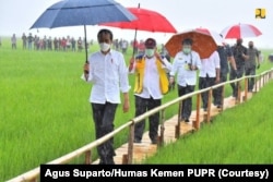 Presiden Joko Widodo didampingi Menteri PUPR Basuki Hadimuljono, Menteri Pertanian Yasin Limpo, dan sejumlah pejabat meninjau areal persawahan yang menjadi kawasan lumbung pangan di Desa Makata Keri, Kecamatan Katiku Tana, Kabupaten Sumba Tengah.