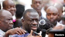 FILE - Uganda's main opposition leader, Kizza Besigye of the Forum for Democratic Change (FDC) party (C), speaks to the media in the capital Kampala.