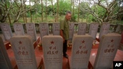War veteran Duong Van Dau walks in between a row of headstones at a memorial for North Korean fallen pilots in Bac Giang province, Vietnam, Feb. 16, 2019. 