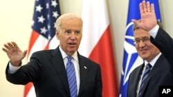 El vicepresidente Joe Biden y el presidente polaco, Bronislaw Komorowski saluda a la prensa luego de conversar en Varsovia sobre la agresión rusa a Ucrania.
