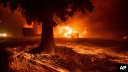 FILE - Flames consume a Kentucky Fried Chicken as the Camp Fire tears through Paradise, Calif., on Nov. 8, 2018. 