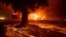 FILE - Flames consume a Kentucky Fried Chicken as the Camp Fire tears through Paradise, Calif., on Nov. 8, 2018. 