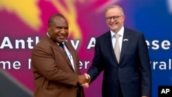 Perdana Menteri Australia Anthony Albanese (kiri) berjabat tangan dengan Perdana Menteri Papua Nugini James Marape di luar parlemen di Port Moresby, Papua Nugini, Kamis, 12 Januari 2023. (Pool Australia via AP)