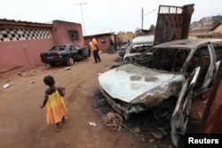 FILE - Burnt cars are seen on the yard of Soumalia Savane, a supporter of Laurent Gbagbo, Ivorian Popular Front (FPI) presidential candidate, in Gagnoa, Nov. 29, 2010.
