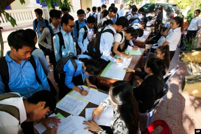 FILE - Students register to participate in a campaign by the National Election Committee, NEC, in Phnom Penh, Cambodia, Wednesday, May 9, 2018.