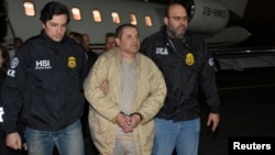 FILE - Mexico's top drug lord Joaquin 'El Chapo' Guzman is escorted as he arrives at Long Island MacArthur airport in New York, Jan. 19, 2017, after his extradition from Mexico. 