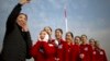 Hospitality staff members react after posing for a selfie during the opening session of China's National People's Congress (NPC) at the Great Hall of the People in Beijing, Monday, March 5, 2018. 