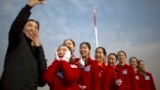 Hospitality staff members react after posing for a selfie during the opening session of China's National People's Congress (NPC) at the Great Hall of the People in Beijing, Monday, March 5, 2018. 