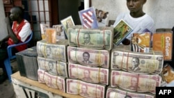 Des liasses de dollars libériens reposent sur la table d’un cambiste à Monrovia, capitale du Liberia, le 3 octobre 2005.