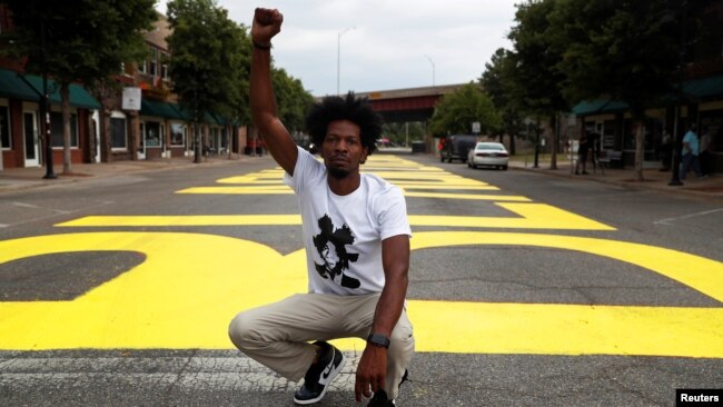 Ricco Wright poses for a photo on a street painted with a 'Black Lives Matter' message to mark Juneteenth, which commemorates the end of slavery in Texas. (REUTERS/Shannon Stapleton)