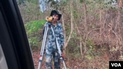 A Chinese worker surveys a road on Samkos mountain in Pursat province’s Ousom commune. The road will connect Koh Kong province to its coastal areas, Cambodia, April 9, 2019. (Sun Narin/VOA Khmer)