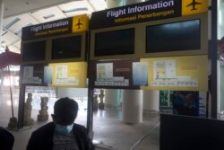 Layar informasi penerbangan di Bandara Internasional Ngurah Rai terlihat kosong sebelum penerbangan internasional dibuka kembali di Bali, Kamis 14 Oktober 2021. (Foto: AP)