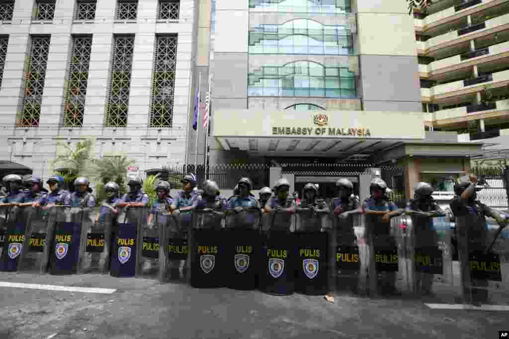 2013年3月5日，在示威者抗议马来西亚进攻婆罗洲岛的菲律宾武装组织后，防暴警察守卫着马尼拉以东的马来西亚大使馆。