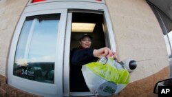在纽约州，快餐店工人把沙拉递给开车经过的顾客