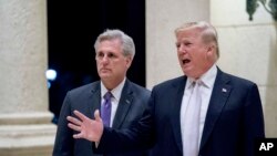 FILE - President Donald Trump, right, accompanied by House Majority Leader Kevin McCarthy, R-Calif., speaks to members of the media as they arrive for a dinner at Trump International Golf Club in West Palm Beach, Florida, Jan. 14, 2018. 