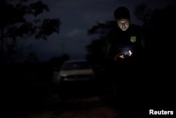 An agent of the Brazilian Institute for the Environment and Renewable Natural Resources, or Ibama, looks at a GPS device during an operation to combat illegal mining and logging, in the municipality of Novo Progresso, Para State, northern Brazil, Nov. 10, 2016.