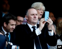 FILE - New Zealand Prime Minister John Key takes photo of the Rugby World Cup final between New Zealand and Australia at Twickenham Stadium, London, Oct. 31, 2015. Comments made by Key caused an uproar in parliament Tuesday.