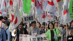 Ratusan pengunjuk rasa di Tokyo (22/9) menggusung bendera Jepang dalam aksi protes menentang klaim Tiongkok atas pulau sengketa Sengkaku (dalam bahasa Jepang). Pulau ini disebut Diayou dalam bahasa Tiongkok.