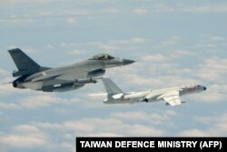 This handout photograph taken and released on May 11, 2018 by Taiwan's Defence Ministry shows a Republic of China (Taiwan) Air Force F-16 fighter aircraft (L) flying alongside a Chinese People's Liberation Army Air Force (PLAAF) H-6K bomber.