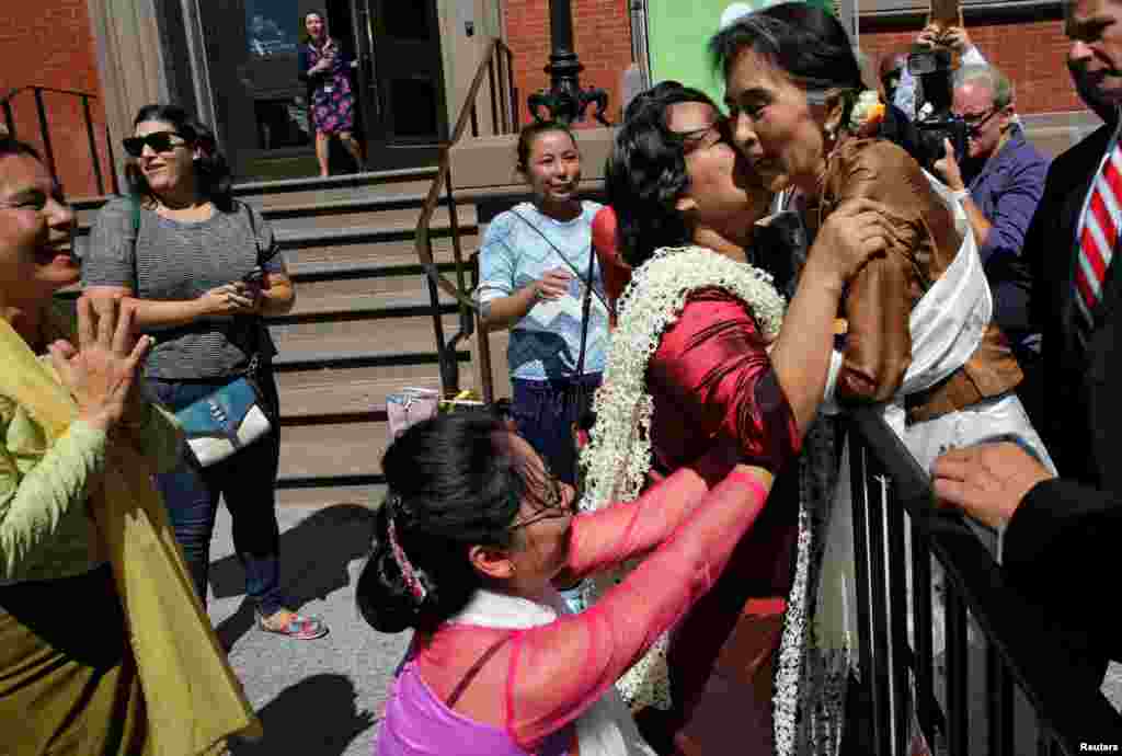 Apoiantes acolhem ministra dos negócios estrangeiros da Birmânia Aung San Suu Kyi junto à Blair House em Washington, D.C., onde almoçou com o secretário de estado americano, John Kerry.