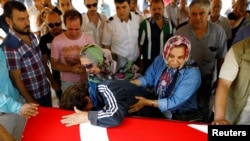 Relatives of Gulsen Bahadir, a victim of Tuesday's attack on Ataturk airport, mourn at her flag-draped coffin during her funeral ceremony in Istanbul, Turkey, June 29, 2016. 