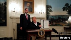 Президент Дональд Трамп подписывает закон о борьбе с коронавирусом в присутствии Алекса Азара, министра здравоохранения и социальных служб, 6 марта 2020 года