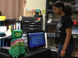 Mahasiswa program robotika cerdas ilmu komputer University of Southern California Kristin Jordan memberikan demonstrasi KIWI, robot pendamping sosial untuk membantu anak-anak dengan gangguan spektrum autisme. (Foto: VOA / Elizabeth Lee)