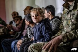 FILE - Iraqi Yazidi children rescued from the Islamic State (IS) group wait to board buses bound for Sinjar in Iraq's Yazidi heartland, April 13, 2019.