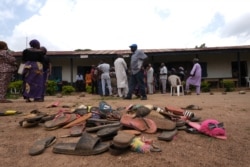 Barang-barang milik siswa Bethel Baptist High School berserakan di halaman sekolah saat orang tua siswa yang diculik berharap epulangan mereka, di Wilayah Pemerintah Daerah Chikun di negara bagian Kaduna, barat laut Nigeria, 14 Juli 2021. (Foto: AFP)