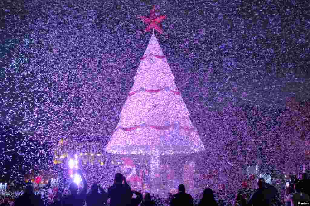 People gather under a Christmas Tree, marking the beginning of Christmas season in Zgharta city, north Lebanon, Dec. 3, 2016.