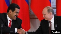 Presiden Rusia Vladimir Putin (kanan) berjabat tangan dengan Presiden Venezuela Nicolas Maduro dalam upacara penandatanganan kerjasama di Kremlin, Moskow (2/7). Presiden Maduro secara lisan mendukung Snowden yang kini menjadi buronan pemerintah AS, dalam upayanya mencari perlindungan politik.